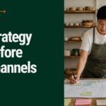 Strategy Before Channels: a small shop owner planning a marketing strategy at a work table