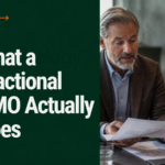 What a Fractional CMO Actually Does: a senior marketing executive reviewing a strategy plan with a business founder